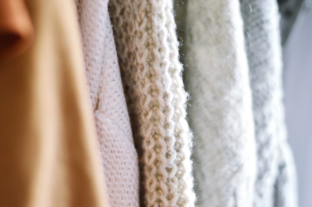 Close up photo of hanging knit sweaters
