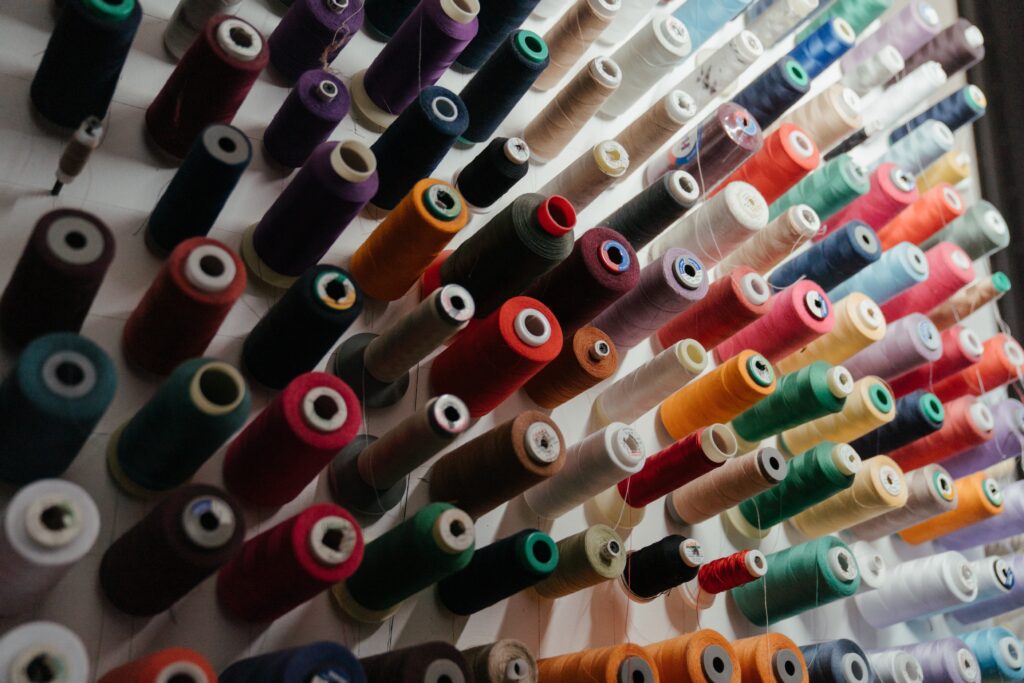 Photo of colorful spools of thread displayed on a rack