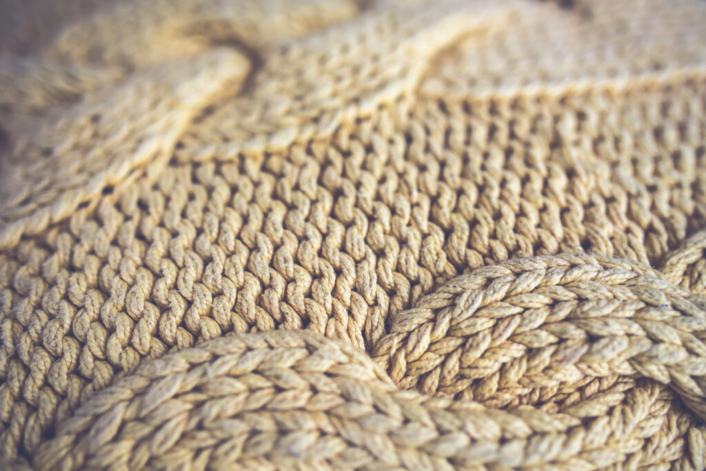 Close up photo of a beige knit wool sweater