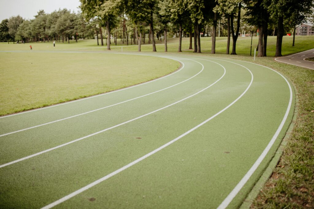 A running track with white lines and trees