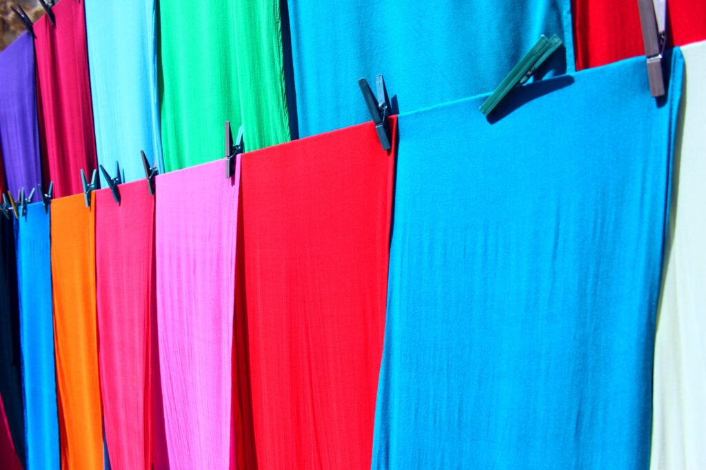 colorful cloth hanging on clothing line with pins