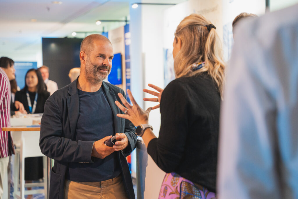 Photo of Erwan Berthou speaking to a member at the Cascale Annual Meeting 2024