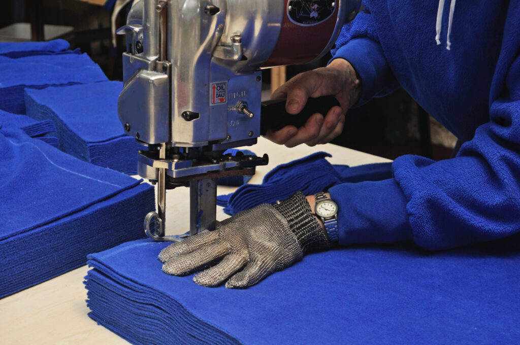 Close up photo of a gloved hand working a sewing machine