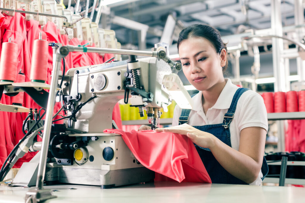 BBPPI Report 2025, an image of a worker sewing a red garment in a facility.