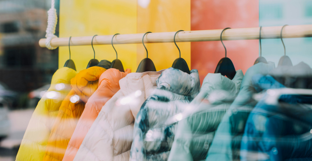 A colorful array of clothing hanging on a garment rack.