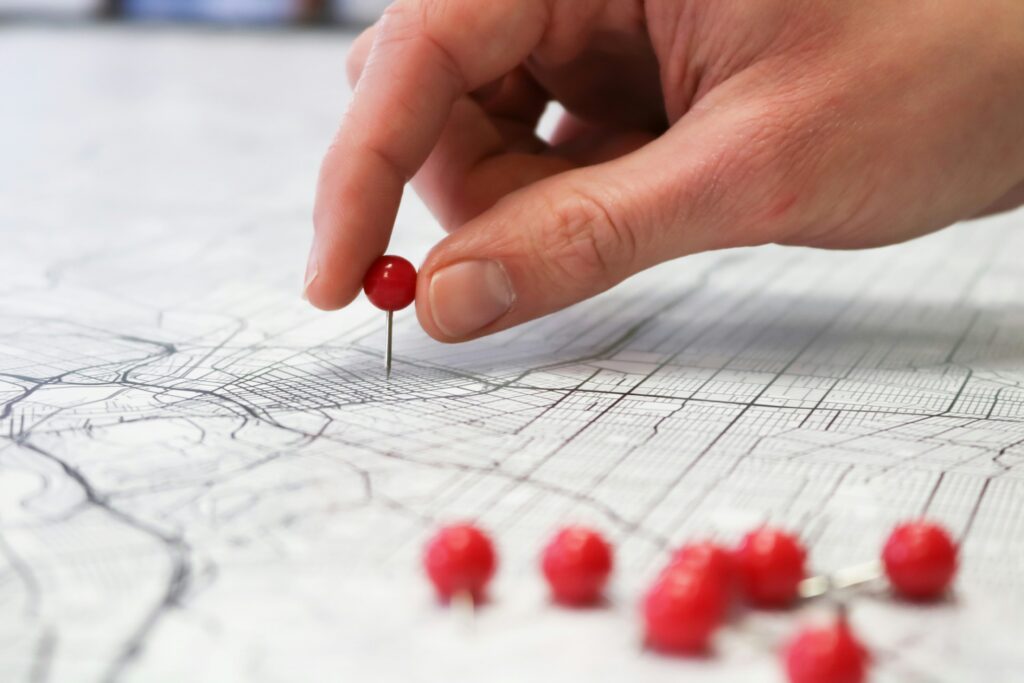 Photo of hand putting a pin on a map
